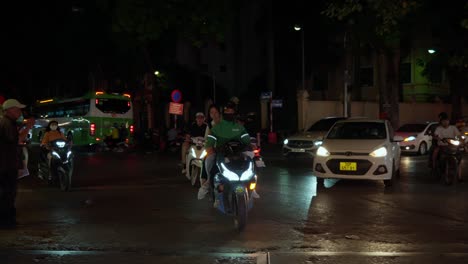 Grab-driver-with-two-passengers-drive-by-busy-street,-night-time