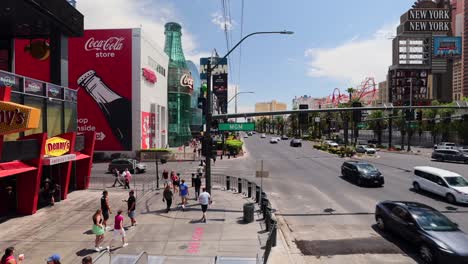 POV-person-riding-down-the-escalator-in-Las-Vegas-Nevada-during-summer-day-with-tourists-walking-along-sidewalk-on-Las-Vegas-Blvd