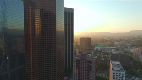 Aerial-view-of-high-rise-buildings-in-Los-Angeles,-California,-bathed-in-low-angle-sunshine,-showcasing-the-city’s-architectural-grandeur