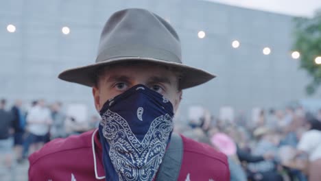 Cowboy-looking-guy,-looking-into-the-camera-at-a-festival