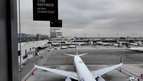 United-airlines-airplane-parked-at-gate-terminal-of-Los-angeles-tom-bradley-internation-LAX-Airport-in-Califorania-USA-during-bad-weather