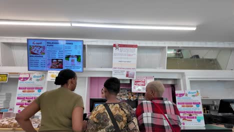 Clientes-Turistas-Comprando-Malasadas-En-Leonard&#39;s-Bakery-En-Oahu,-Honolulu,-Hawai