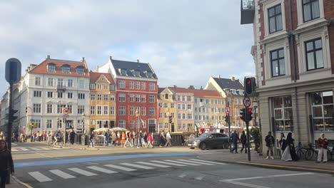 Ein-überfüllter-Nyhaven-In-Kopenhagen-Am-Abend,-Menschen-überqueren-Die-Straßen-Und-Radfahrer-Fahren-Vorbei