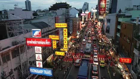 drone-established-of-Yaowarat-road-in-Chinatown-with-traffic-car-street-vendors-stalls-and-neon-sign