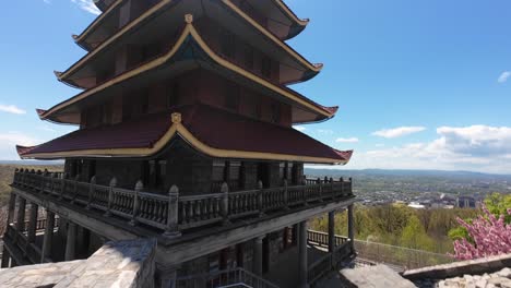 FPV-Flug-Entlang-Des-Pagodengebäudes-Auf-Dem-Berg-Mit-Blick-Auf-Die-Stadt-Im-Tal