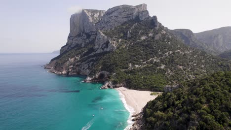 Vista-Aérea-De-Una-Escena-De-Montaña-Y-Playa-En-Cala-Sixtina-En-El-Golfo-De-Orosei-En-Cerdeña,-Italia