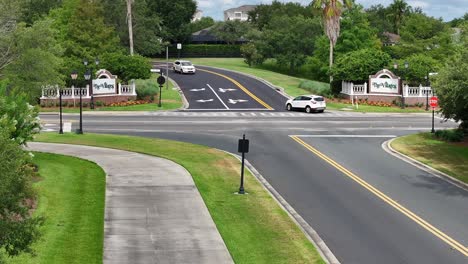 Eingang-Zu-Den-Dörfern-In-Florida-Mit-Autos-Auf-Der-Straße-Und-Einem-Golfwagenweg