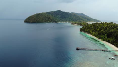 Aerial-dolly-shot-moving-backward-over-the-tranquil-waters-of-Kri-Island,-Raja-Ampat,-Indonesia