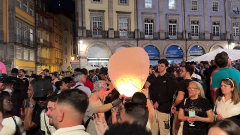 People-light-the-fire-and-release-the-sky-lanterns-during-the-celebration-in-São-João-do-Porto,-Portugal