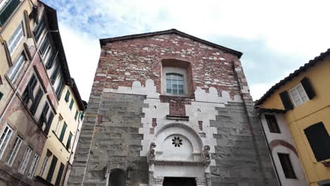 Wide-shot-of-an-old-brick-and-mortar-building-in-the-city-of-Lucca,-Italy-during-a-sunny-day