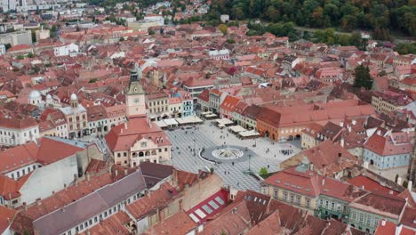 Eine-Europäische-Stadt-Mit-Roten-Dächern-Und-Einem-Zentralen-Platz,-Umgeben-Von-Gebäuden,-Luftaufnahme