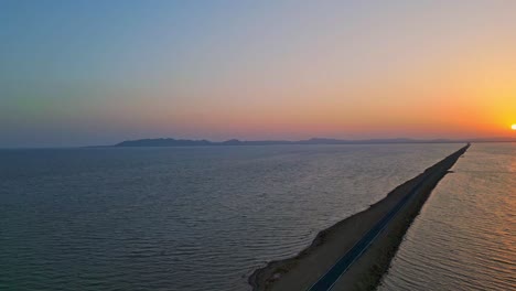 Drone-view-of-beautiful-road-and-salt-water-lake-on-both-sides-in-Kutch,-Road-to-heaven-Gujarat,-India-4K