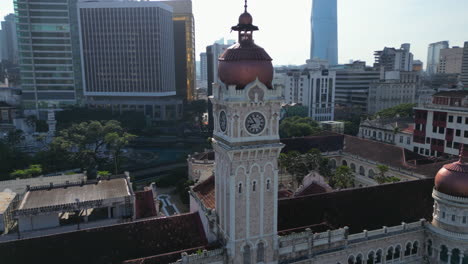 Drone-rotating-the-bell-tower-at-the-Dataran-Merdeka,-sunny-day-in-Kuala-Lumpur