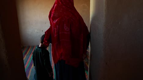 A-disabled,-poor-adult-Afghan-man-seated-in-a-wheelchair,-surrounded-by-his-needy-family-including-children