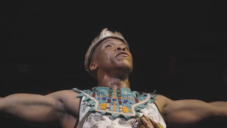 Man-performing-traditional-South-African-tribal-dance-in-colorful-attire-and-headband