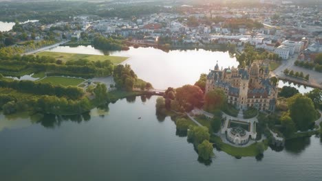 Unique-view-on-the-castle-of-Schwerin,-surrounded-by-lakes-and-green-parks-on-a-sunny-evening,-slow-motion-and-copy-space