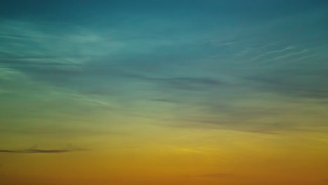 Hermosas-Nubes-Noctilucentes-Iluminadas-Durante-La-Puesta-Del-Sol,-Un-Gradiente-De-Tonos-Azules-Y-Naranjas.