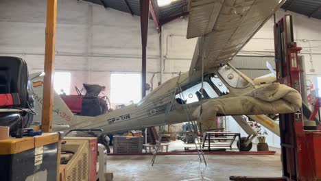 Timelapse-of-a-group-of-airplane-technicians-working-in-a-small-grey-color-airplane-inside-a-workshop