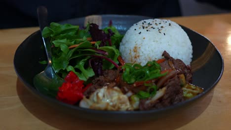 Delicioso-Arroz-Bulgogi-De-Carne-Coreana-Con-Ensalada-Fresca-Al-Costado,-Un-Plato-Favorito-Para-El-Almuerzo-En-Un-Restaurante,-Listo-Para-Devorar-Este-Sabroso-Plato,-Primer-Plano