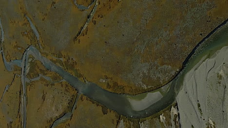 The-Tasman-River-in-New-Zealand-flowing-in-a-valley-from-Mount-Cook---vertical,-tilt-up-aerial-reveal