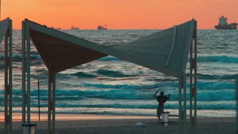 Slow-Motion-Static-Shot-of-Young-Male-Athlete-Doing-a-Cartwheel-on-Beach-at-Golden-Hour