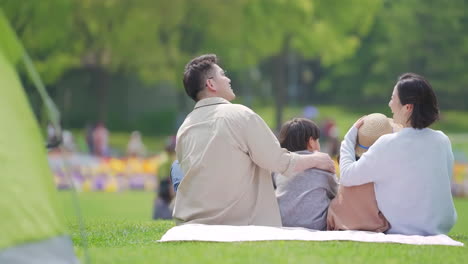 Happy-family-in-the-outdoor-outing-having-a-picnic-in-the-park,-concept-of-destination,-family-travel-and-summer-vacation-or-holidays