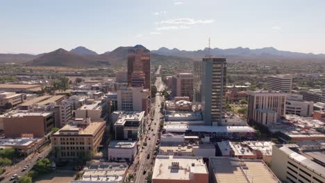 Vuelo-Aéreo-Sobre-El-Centro-De-Tucson,-Arizona,-Durante-El-Día-Con-Una-Impresionante-Cadena-Montañosa-En-El-Horizonte