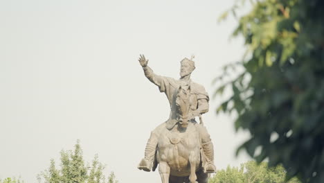 Toma-Estática-De-La-Histórica-Estatua-De-Amir-Timur-En-El-Centro-De-Tashekent,-Uzbekistán,-árboles-Verdes-Alrededor,-Espacio-De-Copia