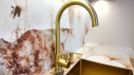 Tap-water-faucet-in-gold-color,-modern-luxury-kitchen-in-small-apartment