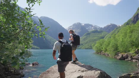 Hikers-reaching-majestic-viewpoint-near-Norway-lake,-static-view