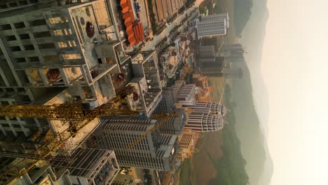 Vertical-aerial-view-of-a-crane-and-construction-site-in-the-Boten-Special-Economic-Zone,-Laos,-near-the-China-border