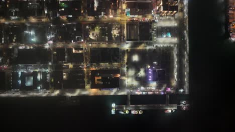 Cenital-drone-shot-at-night-of-lights-and-houses-at-veracruz-port-in-mexico