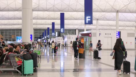 Flugpassagiere-Machen-Sich-Auf-Den-Weg-Zu-Den-Check-in-Schaltern-Der-Fluggesellschaft-In-Der-Terminalhalle-Des-Internationalen-Flughafens-Hongkong-Chek-Lap-Kok