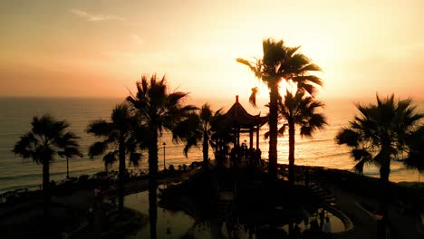 Aerial-view-of-the-Chinese-gazebo-in-Miraflores-Park,-Lima,-surrounded-by-palm-trees