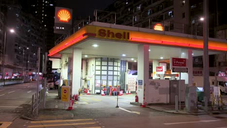 Establishing-view-of-a-Shell-Oil-Company-gas-station-in-Hong-Kong-at-night,-brightly-lit-and-operating