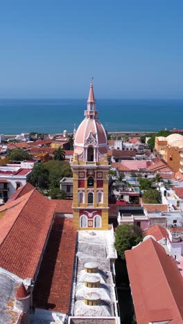 Vertical-Drone-Shot,-Santa-Catalina-Cathedral-in-Old-Town-Cartagena,-Colombia-With-Caribbean-Sea-in-Background