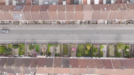 Top-down-drone-view-of-residential-terraced-houses-in-the-UK,-emphasizing-uniform-architecture-and-well-maintained-gardens