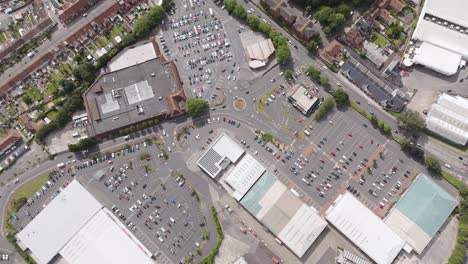 Aerial-drone-orbital-of-the-Bridgwater-retail-park-showing-multiple-stores,-car-parks,-and-surrounding-streets,-Bridgwater,-United-Kingdom