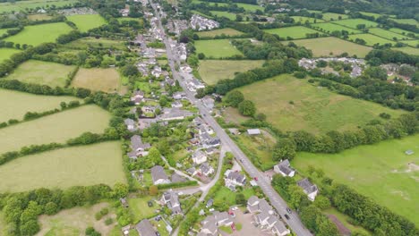 Vista-Aérea-De-La-Capilla-De-Santa-Ana-En-Gunnislake,-Cornualles,-Reino-Unido,-Que-Muestra-El-Pequeño-Pueblo-Rodeado-De-Campos-Verdes-Y-Caminos-Sinuosos.