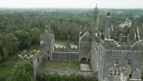 Dromore-castle-in-county-limerick,-ireland-surrounded-by-lush-greenery,-aerial-view