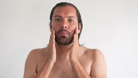 man-doing-skincare-to-take-care-of-his-face,-latin-man,-bearded-man,-face-and-nose-cleansing-and-moisturizing,-daily-care