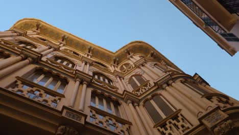 Looking-up-at-ornate-historic-buildings-in-Palma-de-Mallorca,-Spain,-with-clear-blue-skies-above