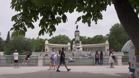 Menschen,-Die-Am-See-Im-Retiro-Park-In-Madrid-Spazieren-Gehen,-Mit-Bäumen-Im-Vordergrund