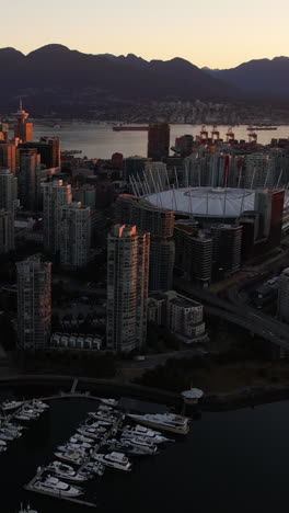 Vista-Aérea-Vertical-De-Vancouver,-Canadá-Al-Amanecer,-Paisaje-Urbano,-Bahía-Y-Edificios-Del-Centro,-Toma-Con-Dron