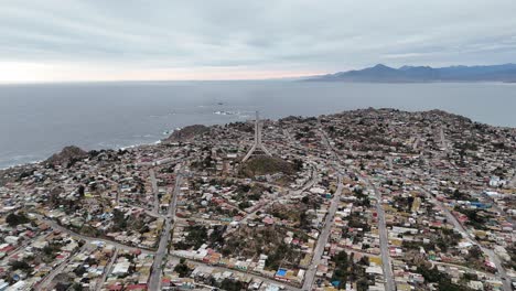 cloudy-day-and-with-the-sunset-of-the-La-Cruz-Monument-of-the-third-millennium,-located-in-Coquimbo,-Chile