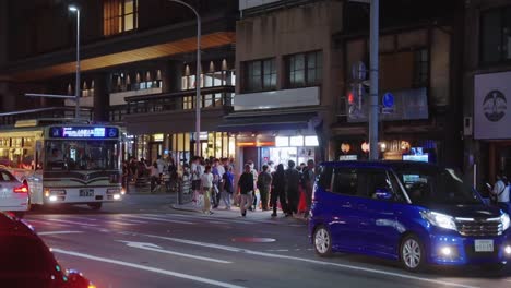 Pan-over-cars-and-buses-traveling-down-street-during-Gion-Matsuri-festival-event