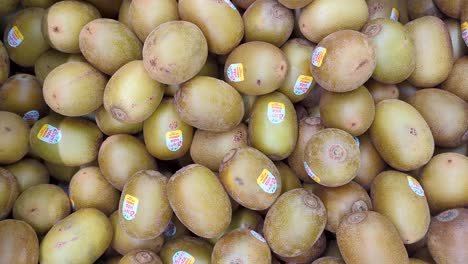 Close-up-of-pile-of-Zespri-SunGold-kiwifruit-groceries-with-stickers-in-fruit-and-vegetable-aisle-of-New-Zealand-supermarket