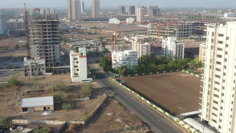 many-high-rise-buildings-in-the-background-with-construction-work-going-on,-field-and-buildings