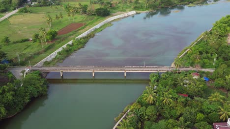 Idyllic-aerial-overview-of-bridge-structure-crossing-quaint-tropical-island-river-in-the-Philippines