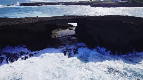 Un-Espectacular-Arco-Costero-Con-Olas-Rompiendo-Debajo,-Mostrando-El-Poder-De-La-Naturaleza-Contra-La-Accidentada-Costa.